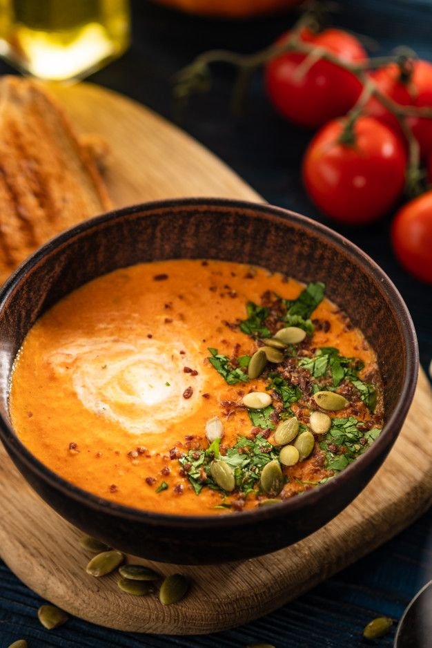 Soupe de potiron à la crème sure et graines de potiron sur une table en bois. | Photo Premium