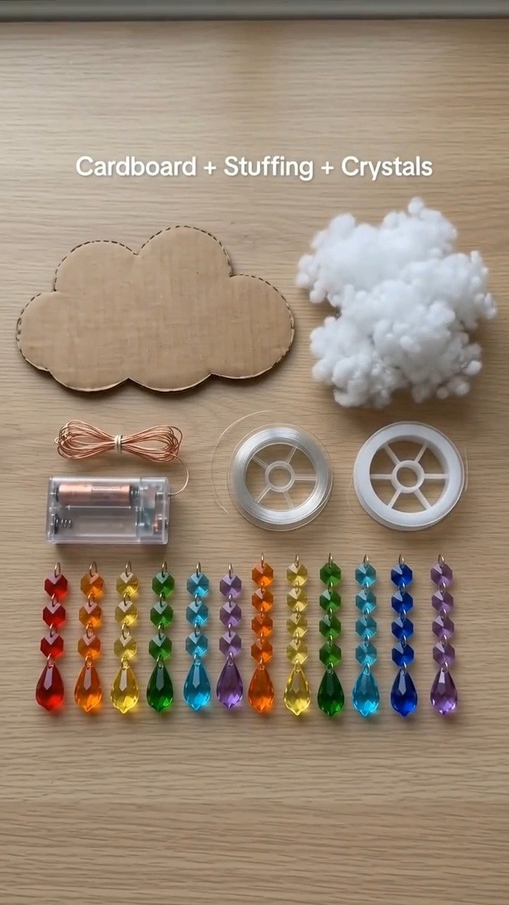 Weiche Pappwolken und farbenfrohe Regenbogenstränge schaffen ein süßes, leichtes Mobile für ein Kinderzimmer, Spielzimmer oder eine fröhliche Bastel-Ecke.